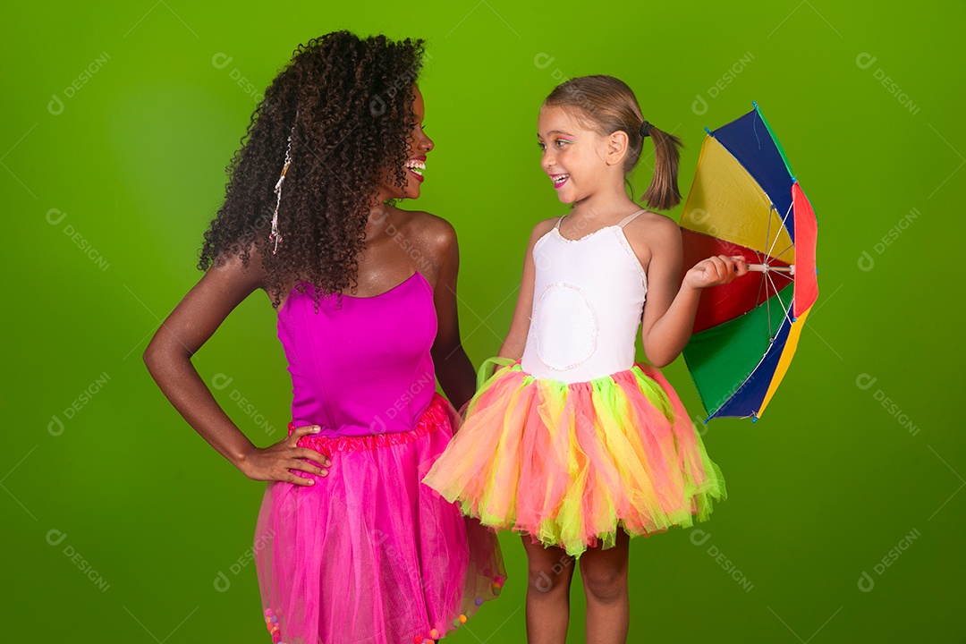 Lindas morena ao lado de sua filha loira fantasiada segurando guarda-chuva sobre fundo verde isolado