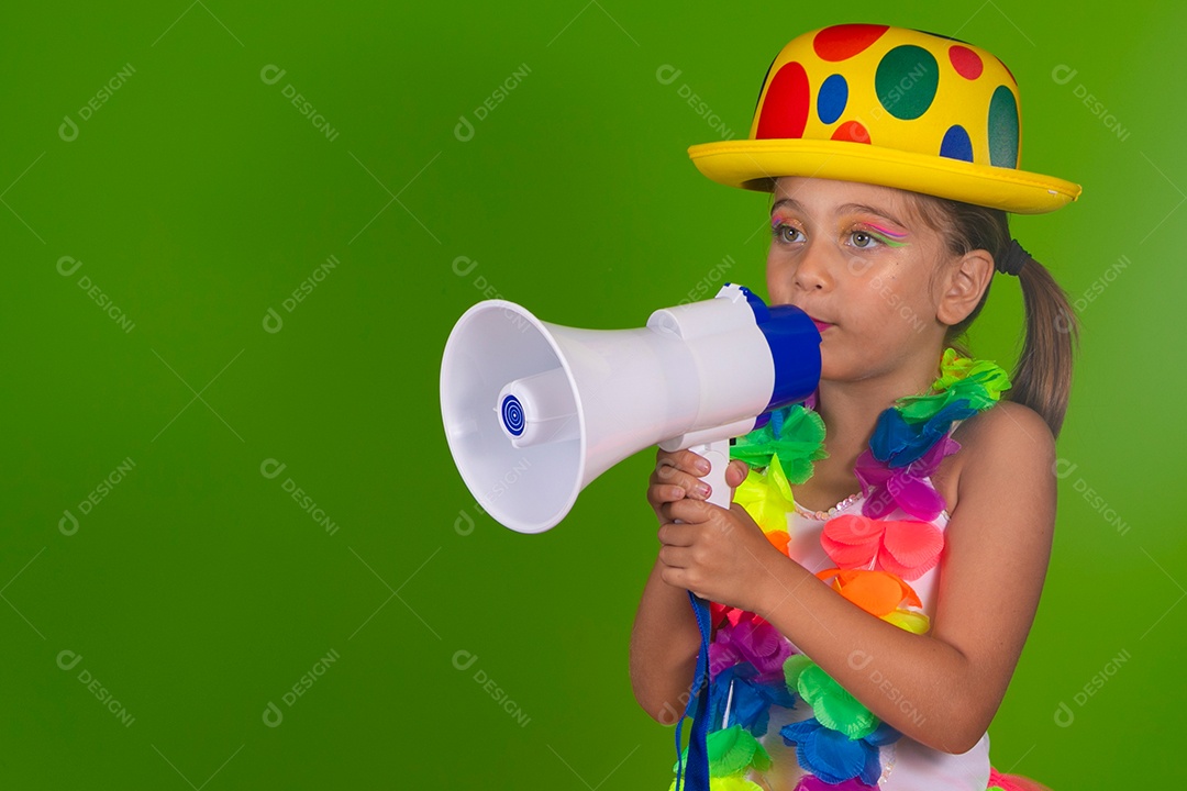 Linda garotinha loira fantasiada para carnaval segurando magafone sobre fundo verde isolado