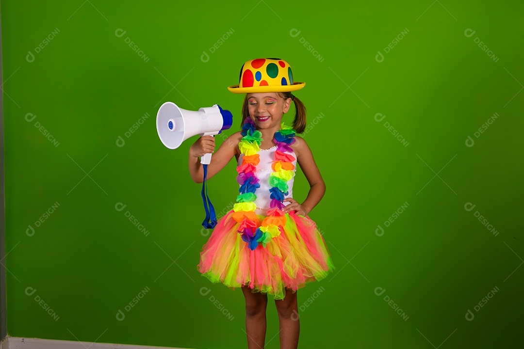 Linda garotinha loira fantasiada para carnaval segurando magafone sobre fundo verde isolado