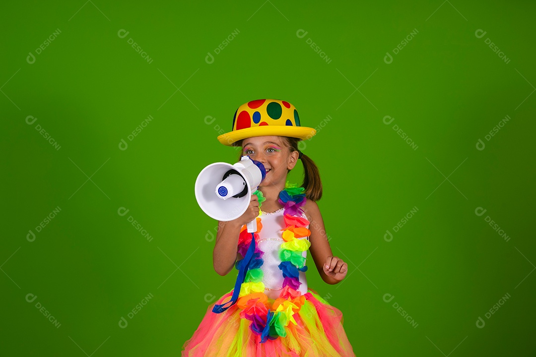 Linda garotinha loira fantasiada para carnaval segurando magafone sobre fundo verde isolado