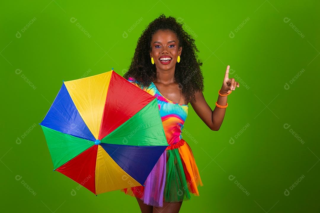 Linda morena fantasiada sorridente segurando guarda-chuva sobre fundo verde isolado