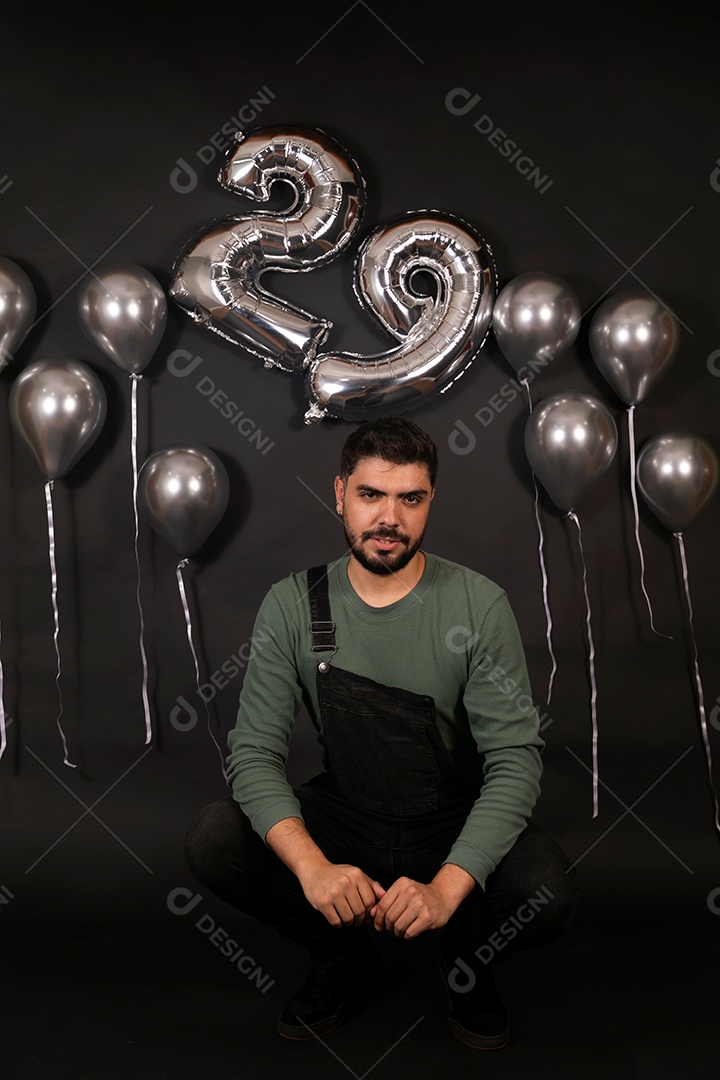 Lindo homem fazendo aniversário sobre fundo com balões isolado