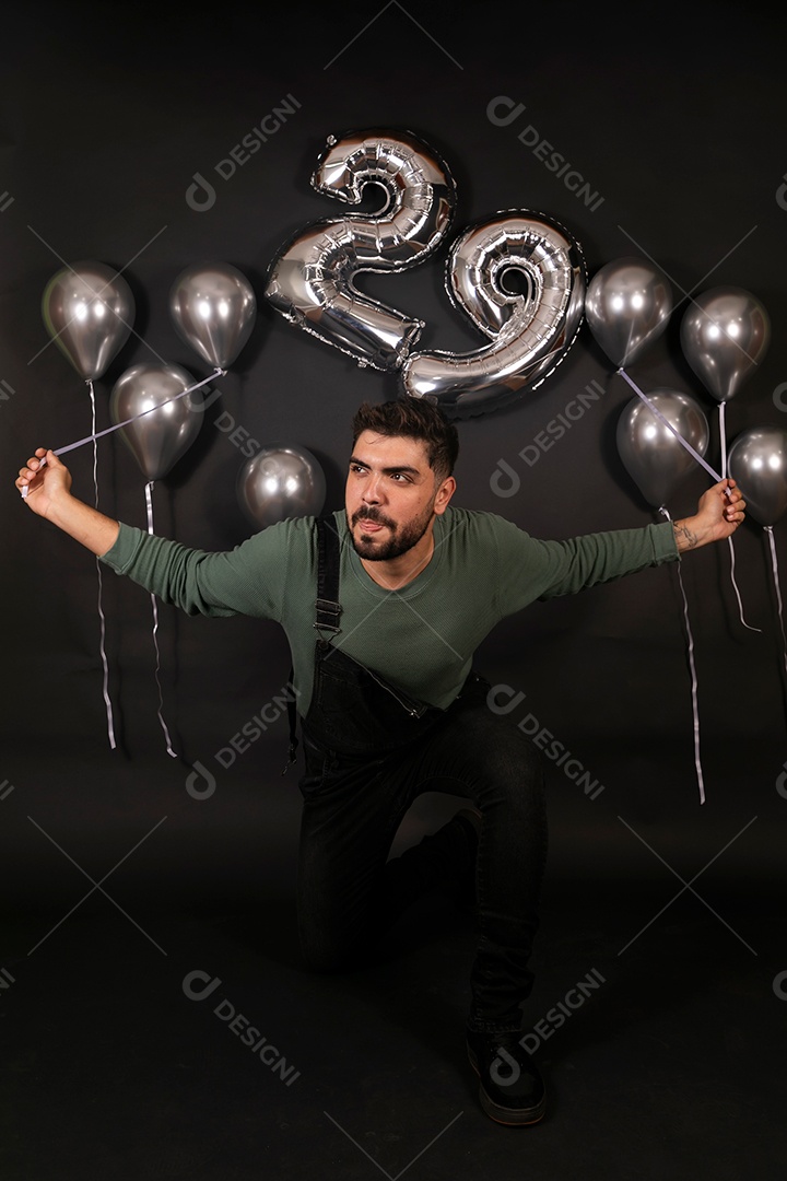 Lindo homem fazendo aniversário sobre fundo com balões isolado
