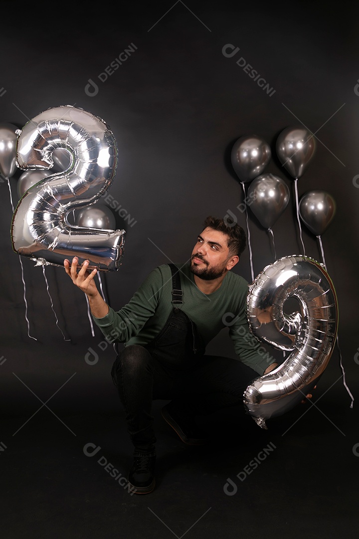 Lindo homem fazendo aniversário sobre fundo com balões isolado