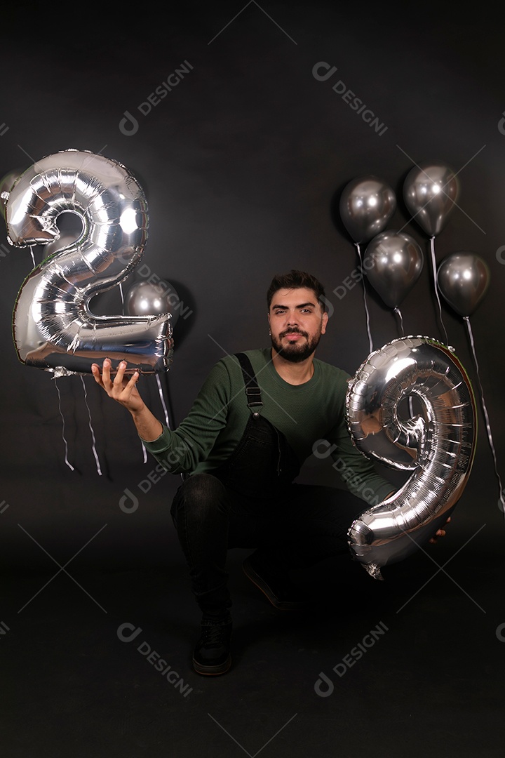 Lindo homem fazendo aniversário sobre fundo com balões isolado