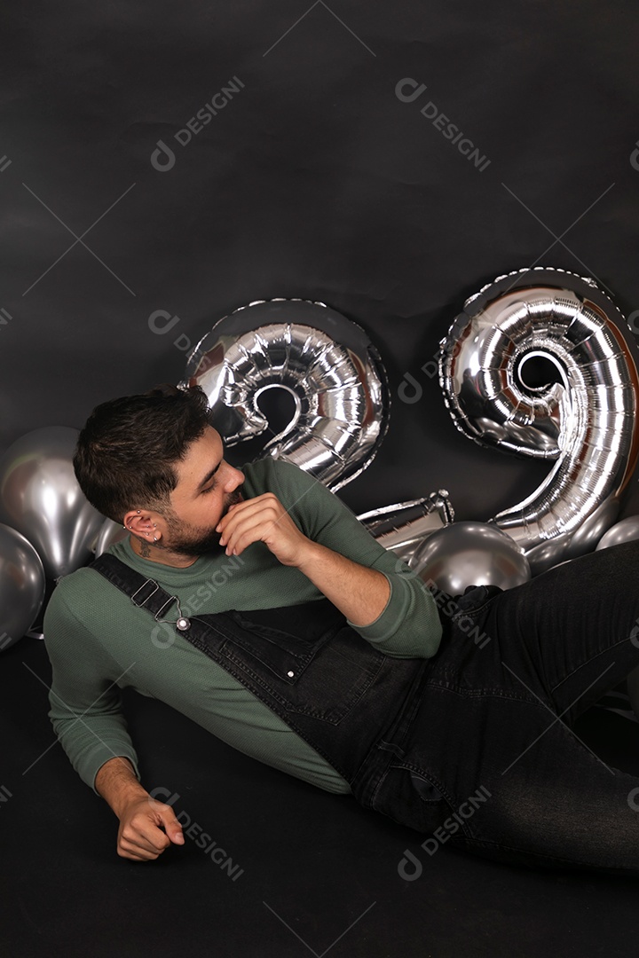 Lindo homem sorridente fazendo aniversário sobre fundo com balões isolado