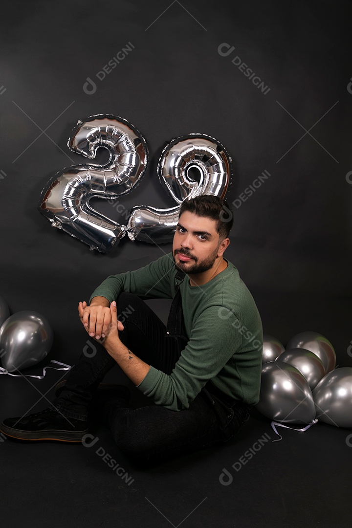 Lindo homem sorridente fazendo aniversário sobre fundo com balões isolado