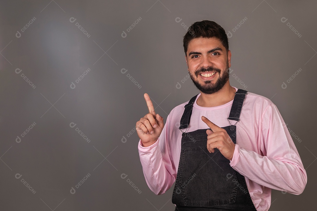 Lindo homem usando macacão preto sobre fundo laranja isolado