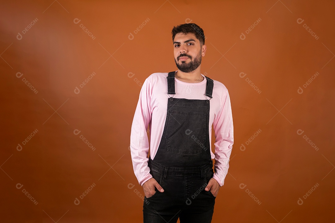 Lindo homem usando macacão preto sobre fundo laranja isolado