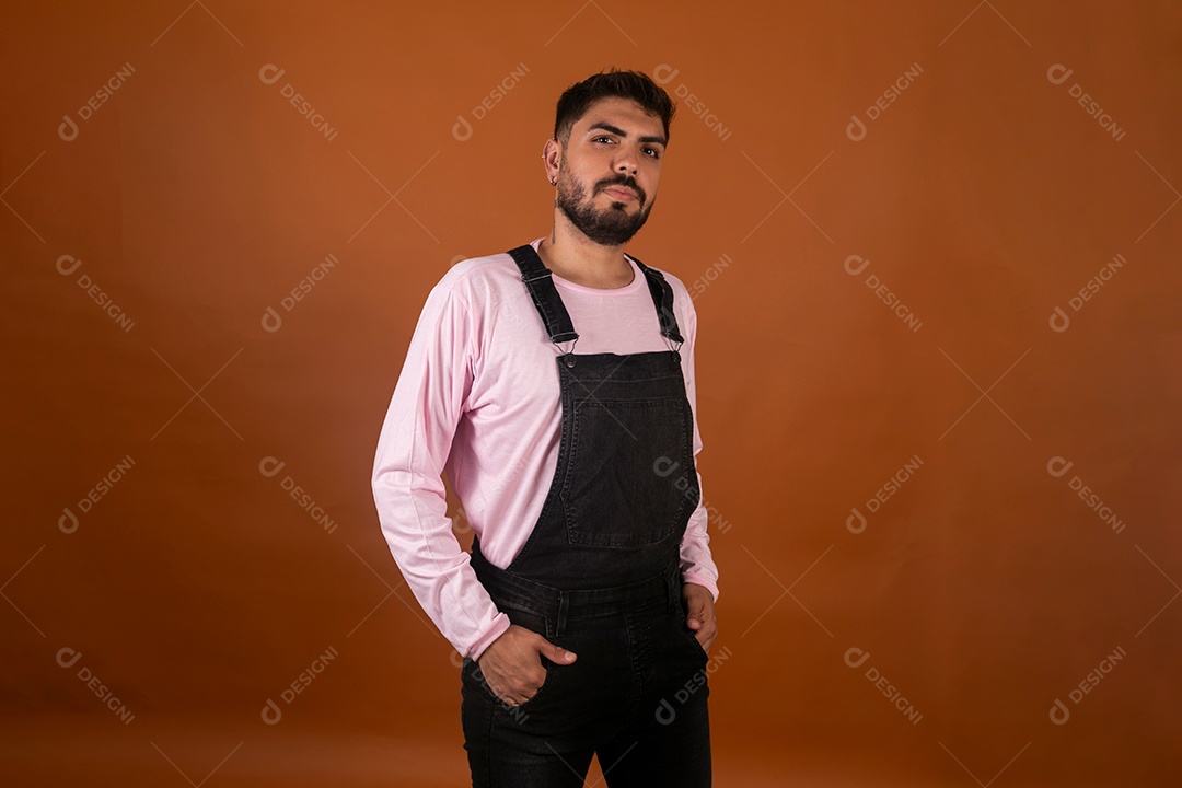 Lindo homem usando macacão preto sobre fundo laranja isolado