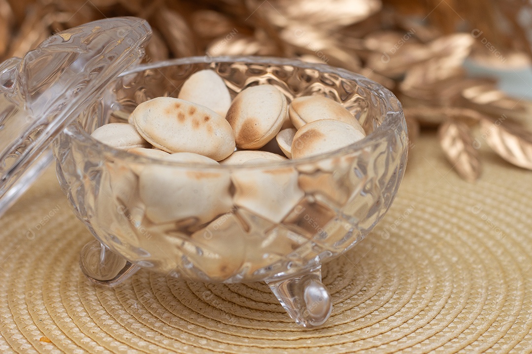 Biscoitos em tijela de vidro sobre mesa de madeira