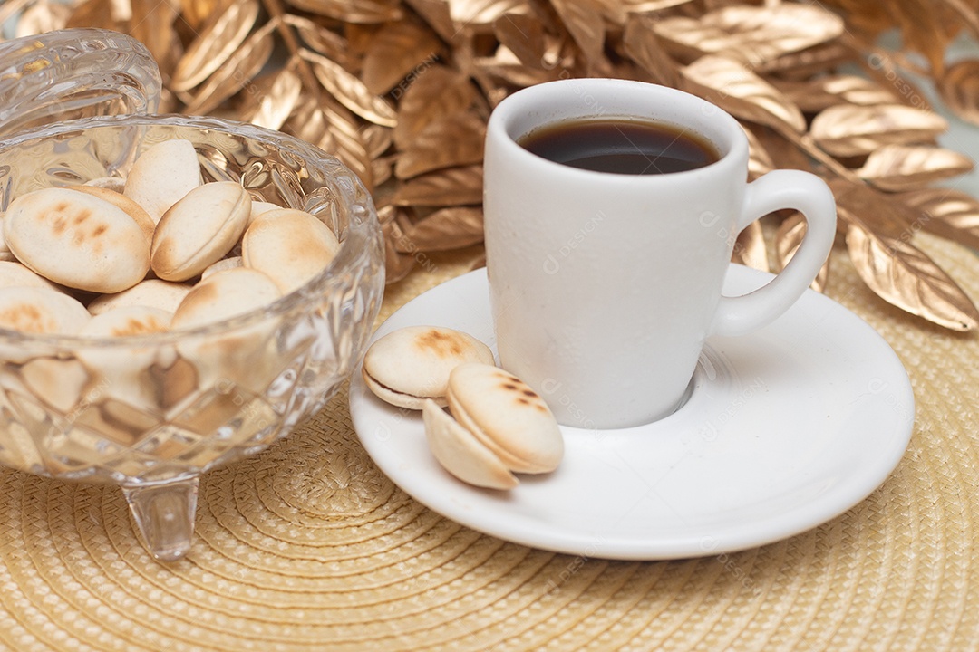 Xícara de café com biscoitos sobre mesa de madeira