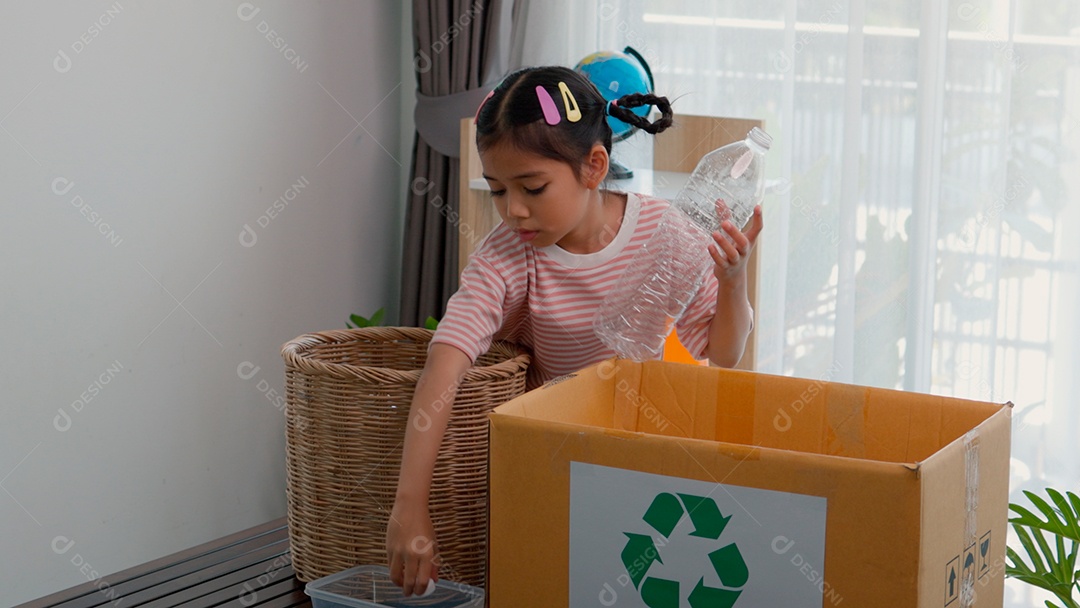 Linda garotinha usando roupa de dormir segurando garrafas de plástico sobre fundo de um quarto isolado