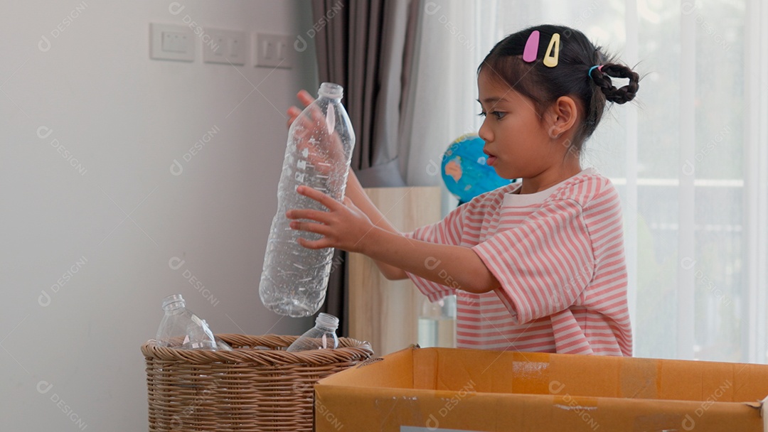 Linda garotinha usando roupa de dormir segurando garrafas de plástico sobre fundo de um quarto isolado
