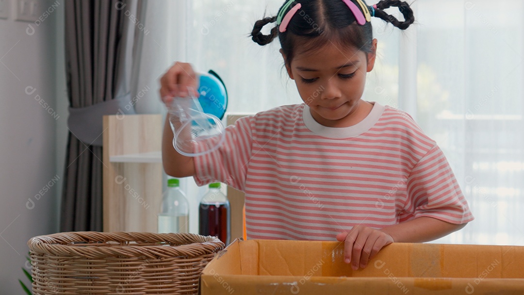 Linda garotinha usando roupa de dormir segurando garrafas de plástico sobre fundo de um quarto isolado