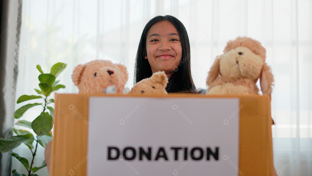 Linda garota sorridente segurando brinquedos para doação