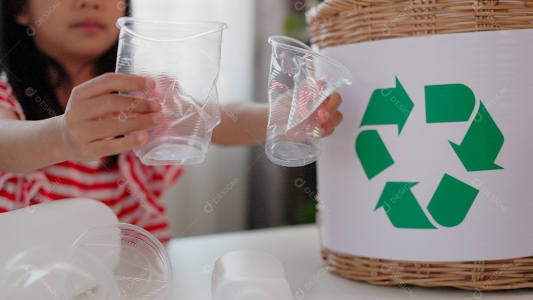 Linda garotinha segurando copos para reciclagem