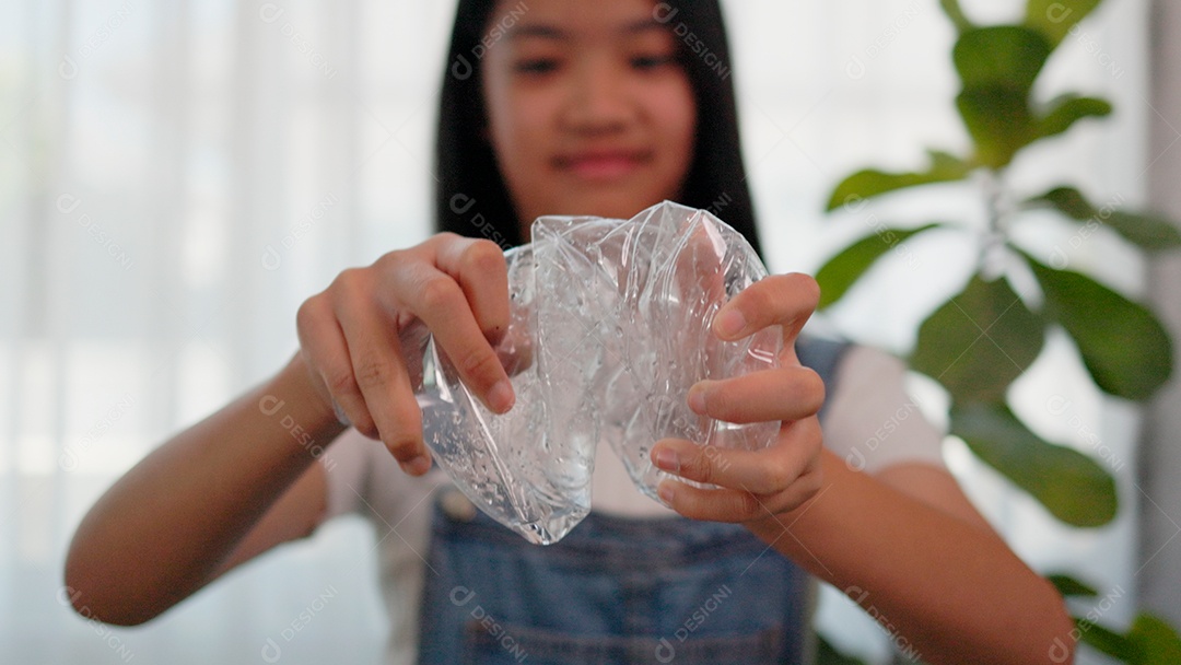 Linda menina amassando garrafa pet