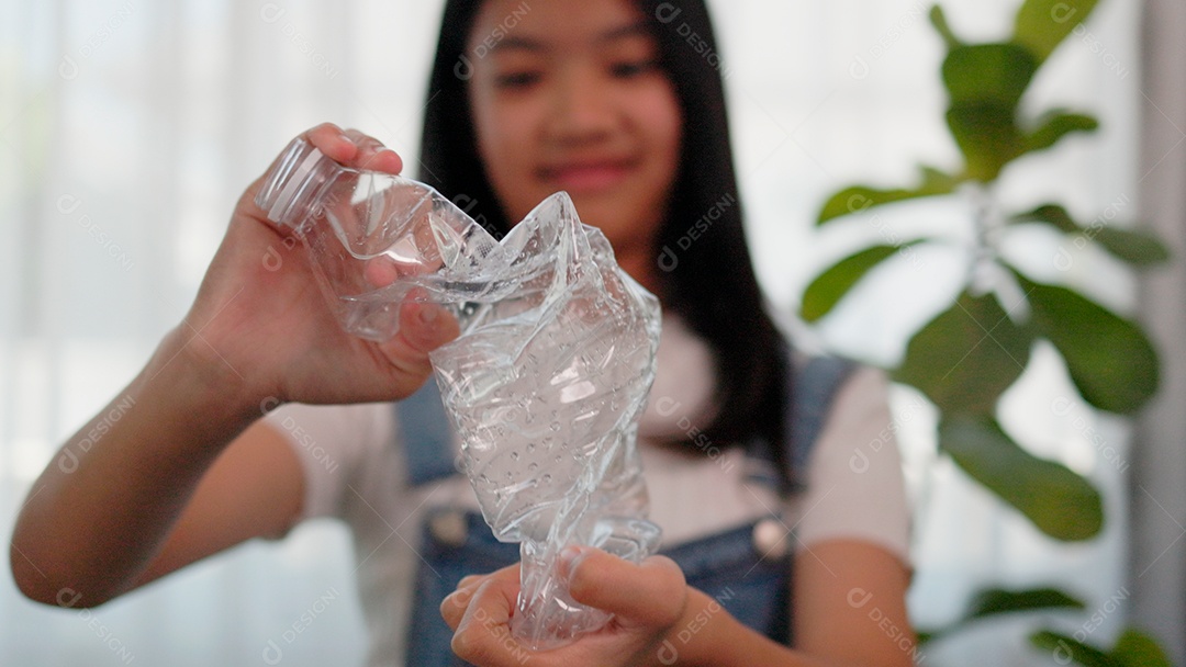 Linda menina amassando garrafa pet