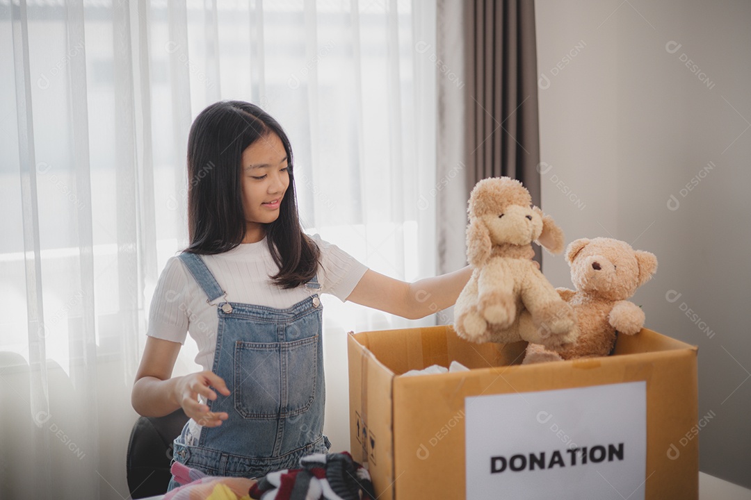 Linda garota sorridente segurando brinquedos para doação