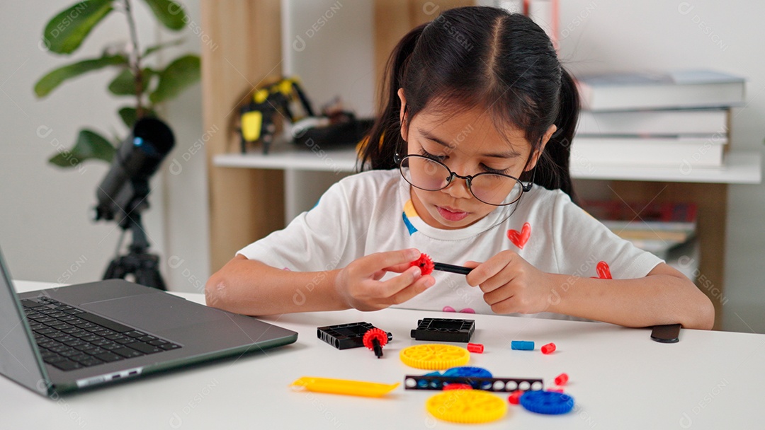 Linda garota de óculos apontando lápis e mechendo em leptop sobre mesa de madeira