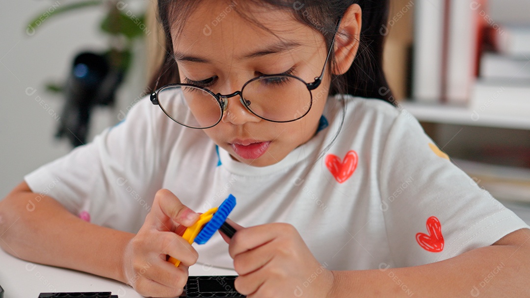 Linda garota de óculos  brincando sobre mesa de madeira