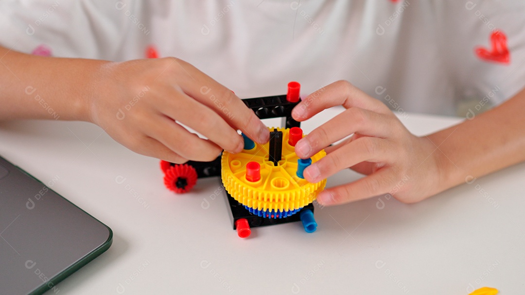 Linda criança brincando ao lado de leptop sobre fundo de um quarto