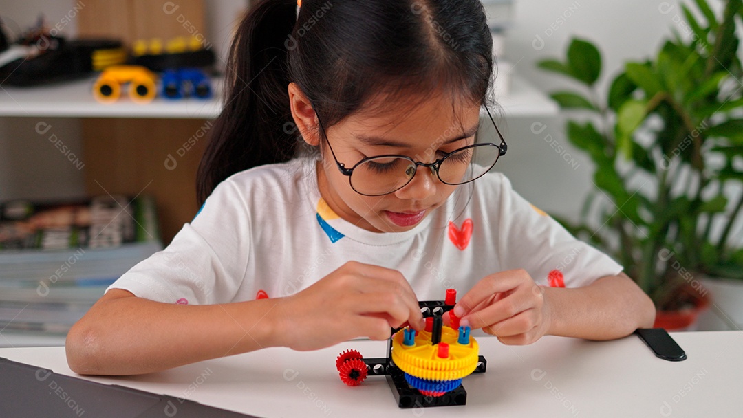 Linda criança brincando ao lado de leptop sobre fundo de um quarto