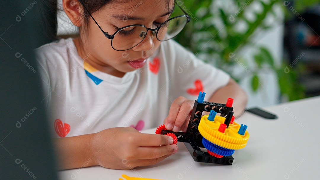 Linda criança brincando ao lado de leptop sobre fundo de um quarto