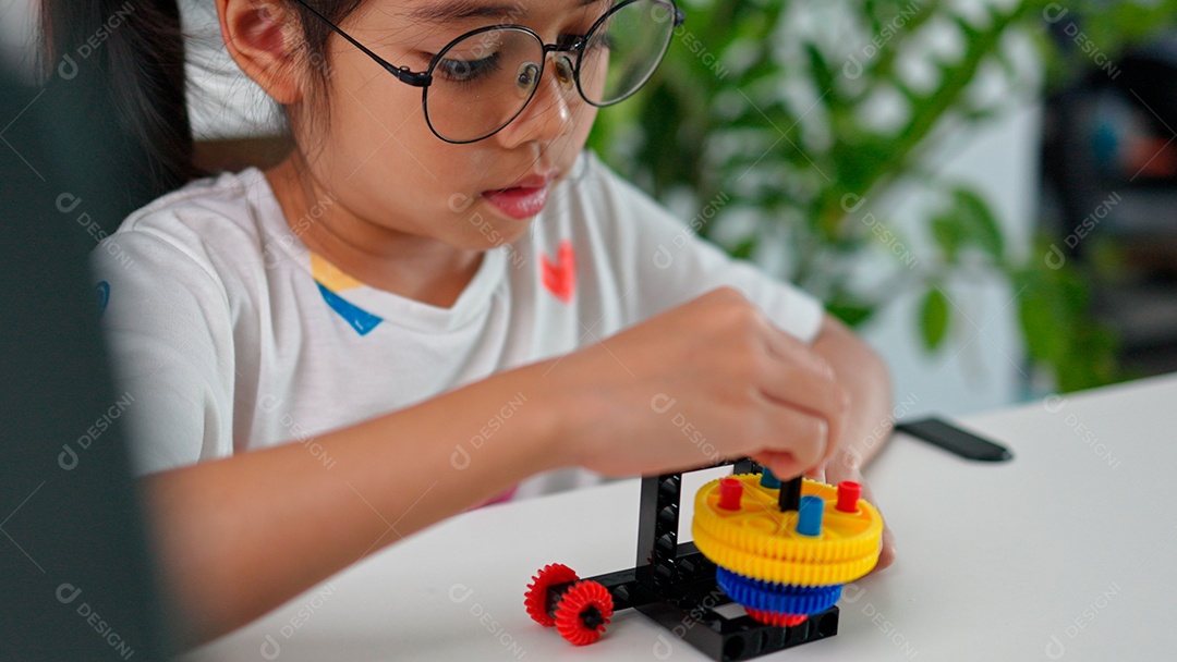 Linda criança brincando ao lado de leptop sobre fundo de um quarto