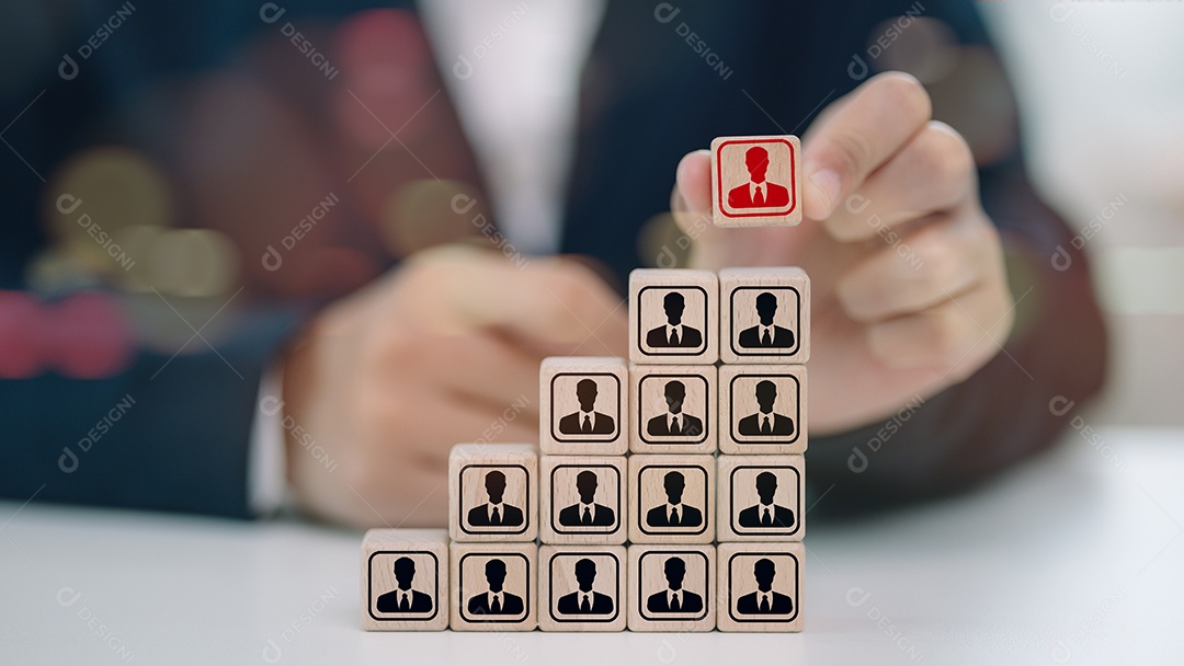 Mão de empresário empilhando cubo de madeira sobre fundo desfocado