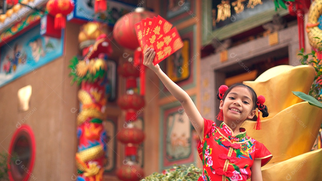 Linda menina asiática feliz vestindo uma decoração de cheongsam tradicional chinesa vermelha sobre fundo desfocado