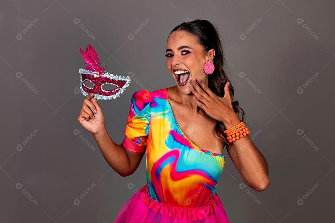 Linda mulher sorridente fantasiada segurando máscara sobre fundo isolado