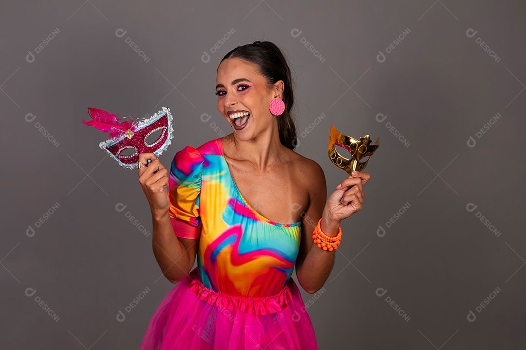 Linda mulher sorridente fantasiada segurando máscara sobre fundo isolado