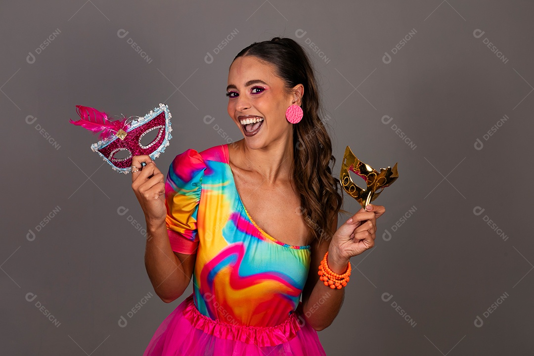 Linda mulher sorridente fantasiada segurando máscara sobre fundo isolado