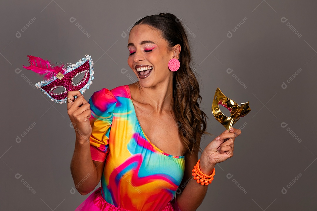 Linda mulher sorridente fantasiada segurando máscara sobre fundo isolado