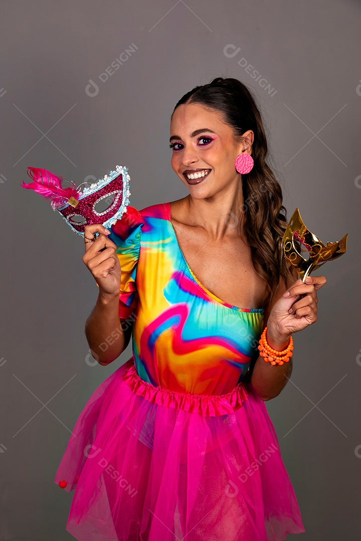 Linda mulher sorridente fantasiada segurando máscara sobre fundo isolado