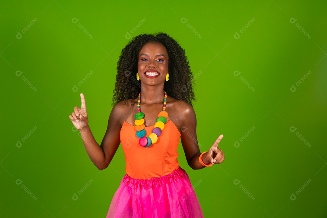 Linda morena do cabelo cacheado sorridente fantasiada sobre fundo verde isolado