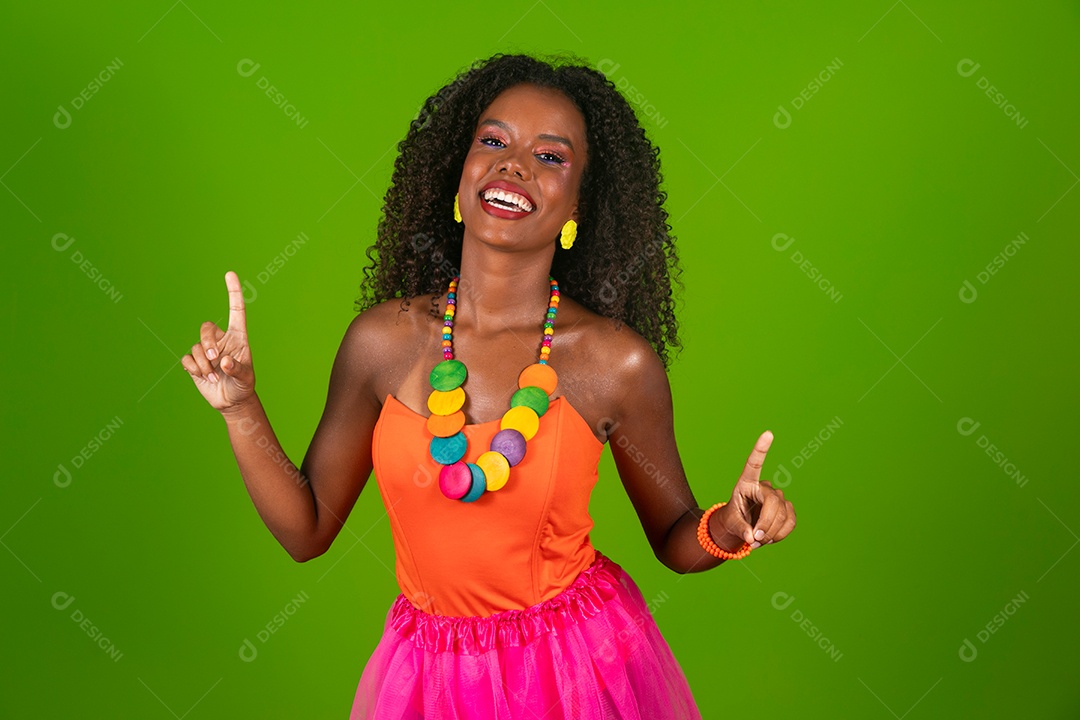 Linda morena do cabelo cacheado sorridente fantasiada sobre fundo verde isolado