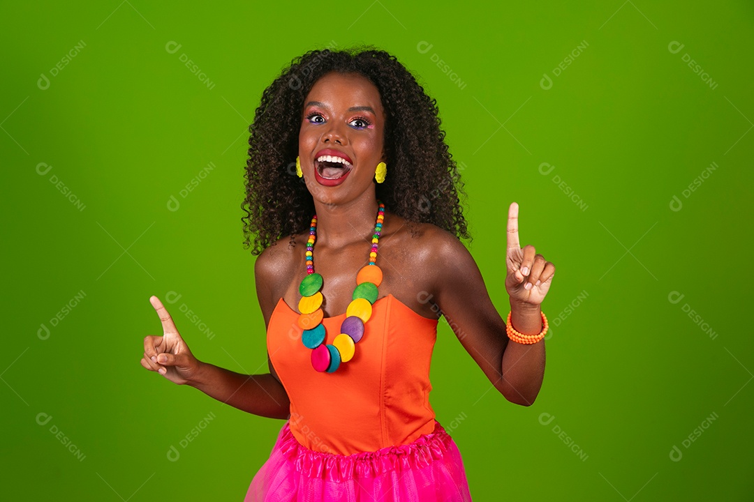 Linda morena do cabelo cacheado sorridente fantasiada sobre fundo verde isolado