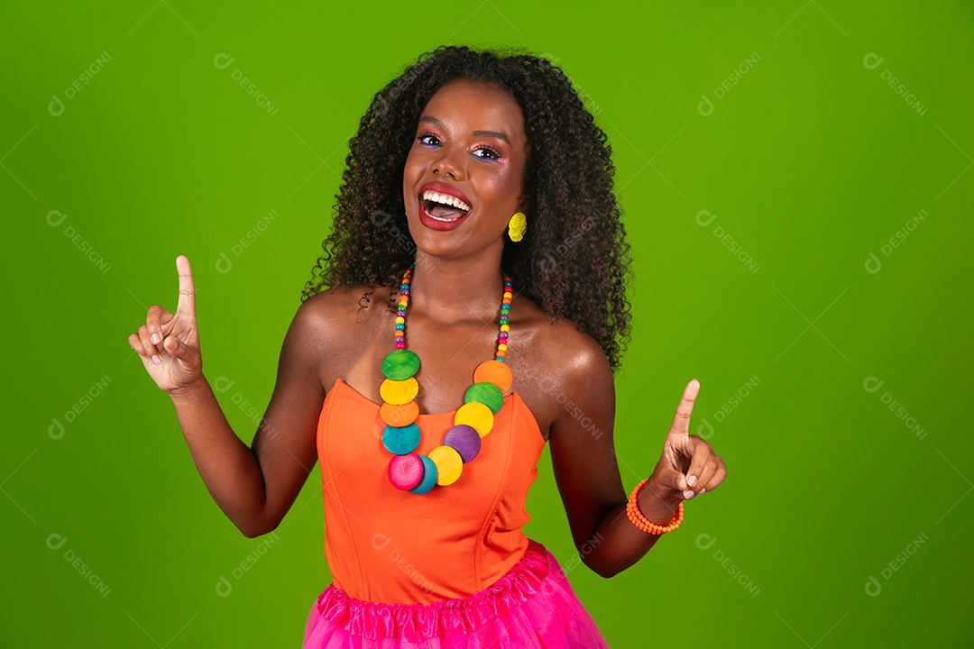 Linda morena do cabelo cacheado sorridente fantasiada sobre fundo verde isolado