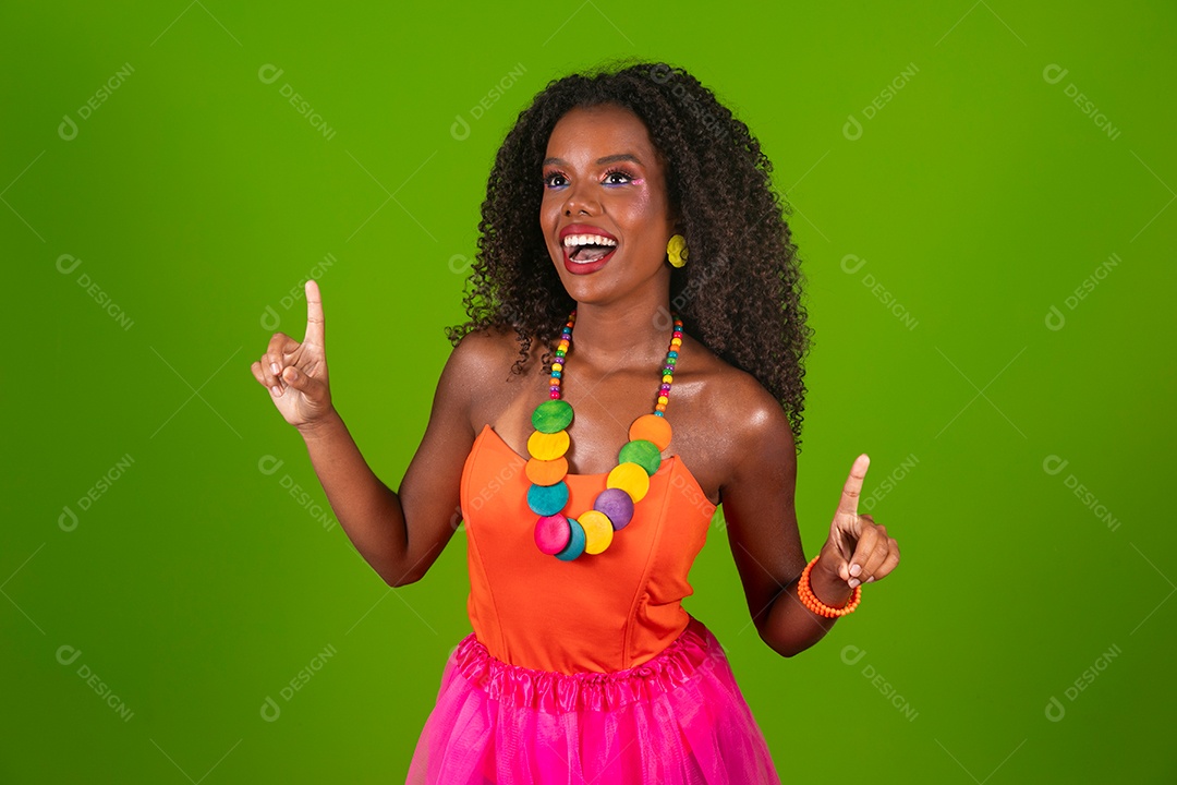 Linda morena do cabelo cacheado sorridente fantasiada sobre fundo verde isolado