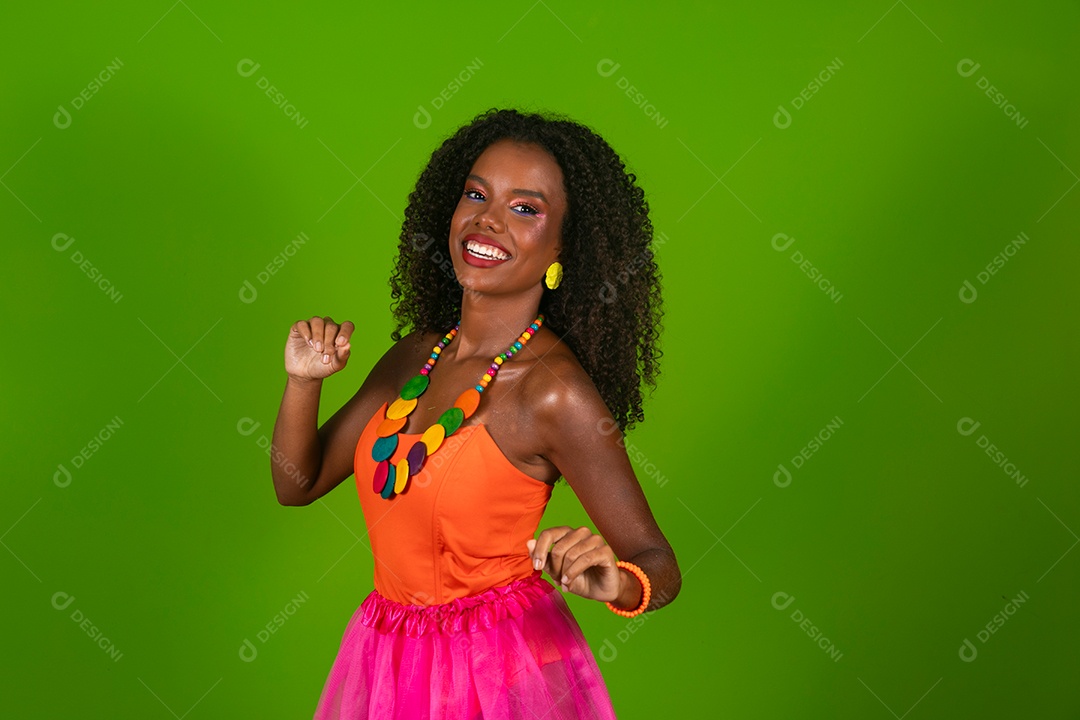 Linda morena do cabelo cacheado sorridente fantasiada sobre fundo verde isolado