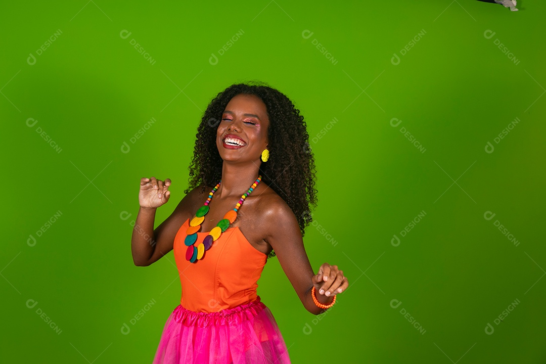 Linda morena do cabelo cacheado sorridente fantasiada sobre fundo verde isolado