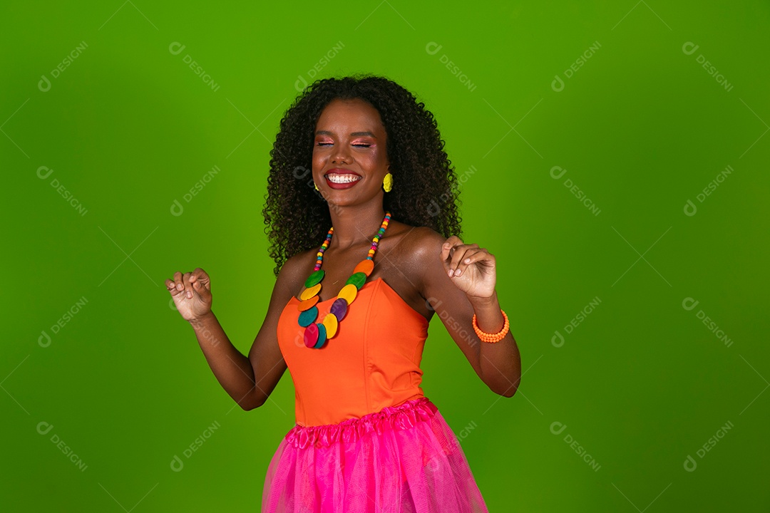 Linda morena do cabelo cacheado sorridente fantasiada sobre fundo verde isolado