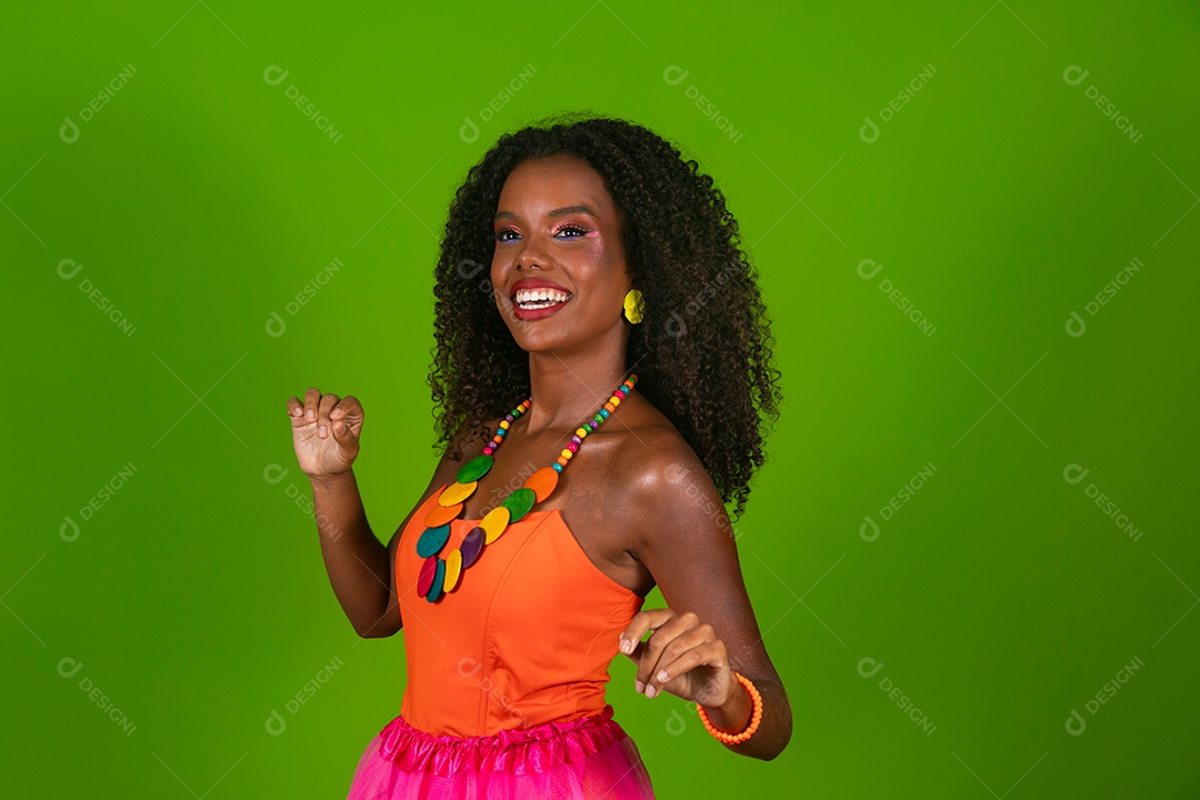 Linda morena do cabelo cacheado sorridente fantasiada sobre fundo verde isolado