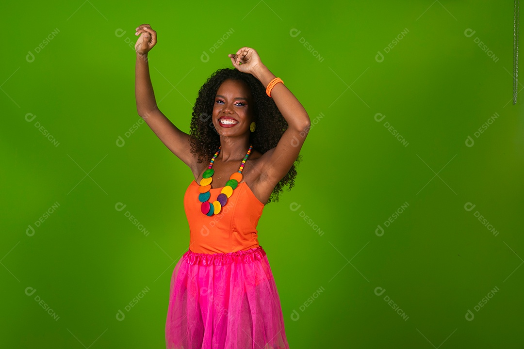 Linda morena do cabelo cacheado sorridente fantasiada sobre fundo verde isolado