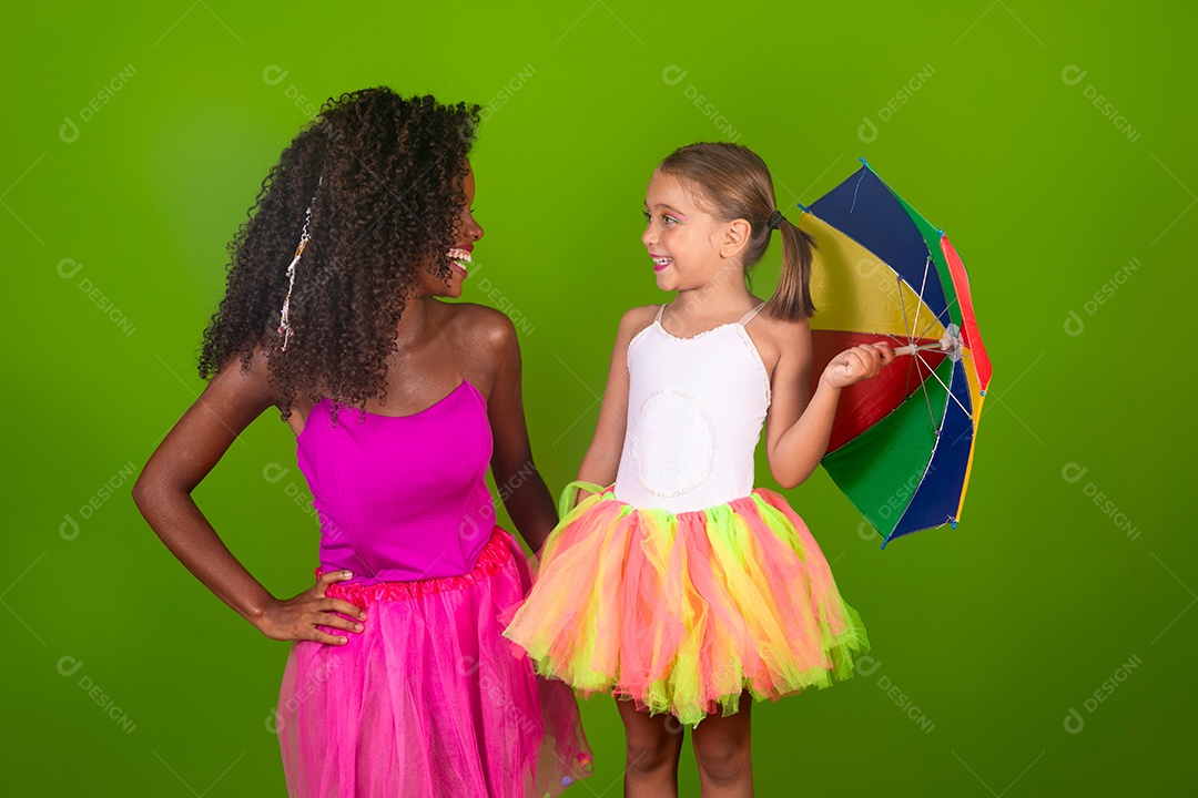 Duas lindas mulheres usando conjunto de carnaval segurando guarda-chuva sobre fundo verde isolado