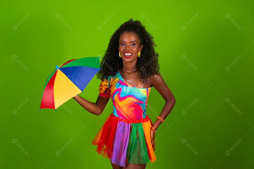 Linda morena do cabelo cacheado sorridente fantasiada segurando guarda-chuva sobre fundo verde isolado