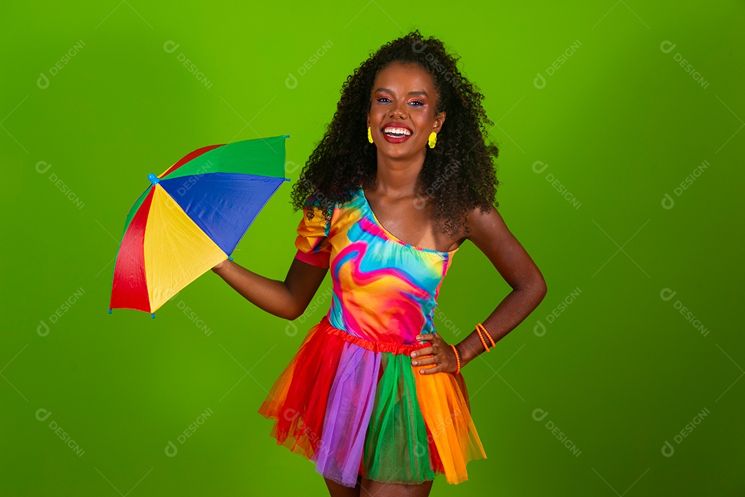Linda morena do cabelo cacheado sorridente fantasiada segurando guarda-chuva sobre fundo verde isolado